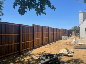 New wood fence installation with construction materials on site by 3M Custom Fence in Lewisville, TX.