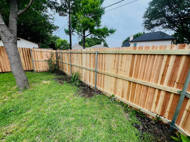 A newly installed wooden fence with sturdy metal posts in a backyard by CW Fence and Fab in Forney, TX.