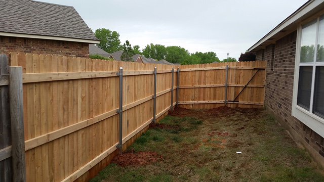 A newly constructed wooden fence featuring durable metal posts by T&G Outdoor Services in Austin, TX.