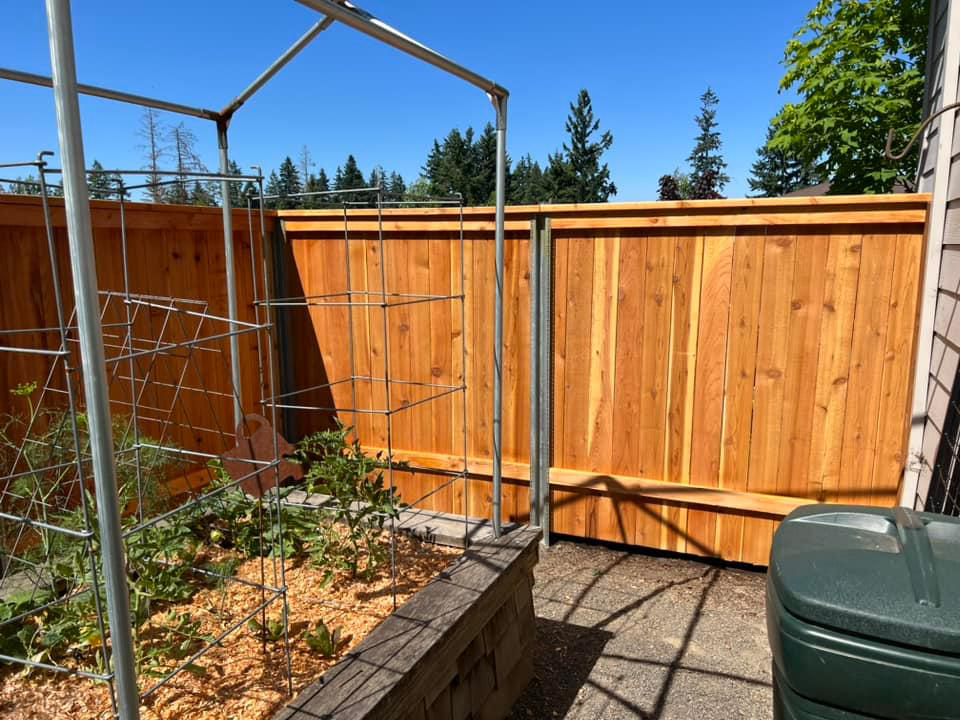 A new wood fence installed next to a garden area by RL Quality construction in Gaston, OR.