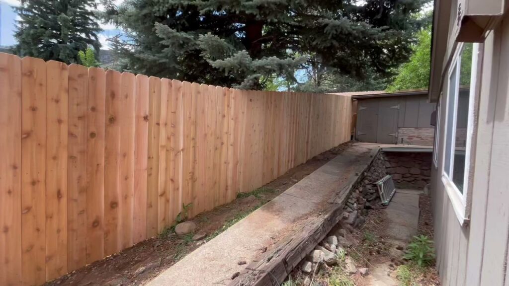 A newly installed wood fence running alongside a concrete pathway by Supreme Fencing Denver, CO.