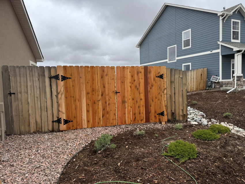 A new section of wooden fence and gate installed, blending with an older fence by Slater Fence Co in Houston, TX.