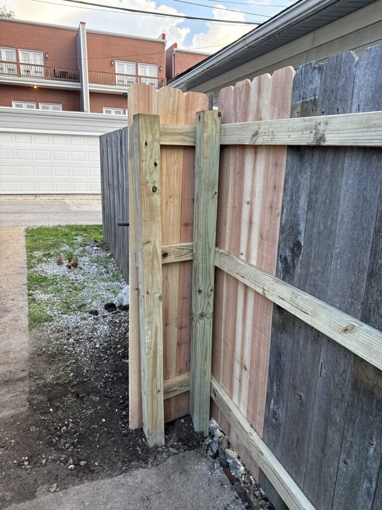 A new wood fence section being installed, showing fresh lumber next to an older fence by Exterior Experience LLC in St. Louis, MO.