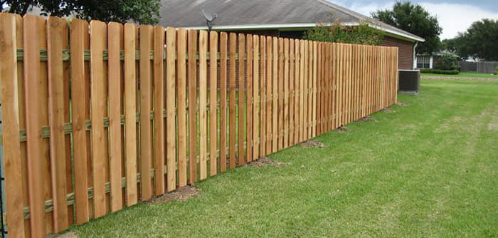 A newly installed wood picket fence in a residential backyard by Freedom Fencing of Clarksville, TN.