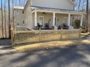 A newly installed wood picket fence in the front yard of a residential home by Premier Fence of Birmingham, LLC in Warrior, AL.