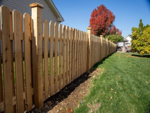 A newly installed wood picket fence in a residential backyard by Vanguard Fencing LLC in Lenexa, KS.