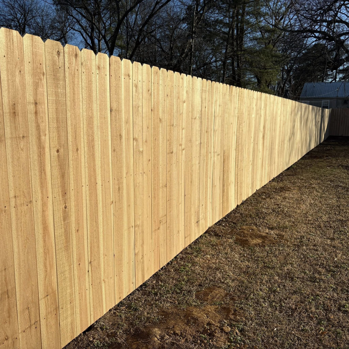 An angled view of a new wood picket privacy fence installed by McDaniel Quality Fencing LLC in Muldrow, OK.