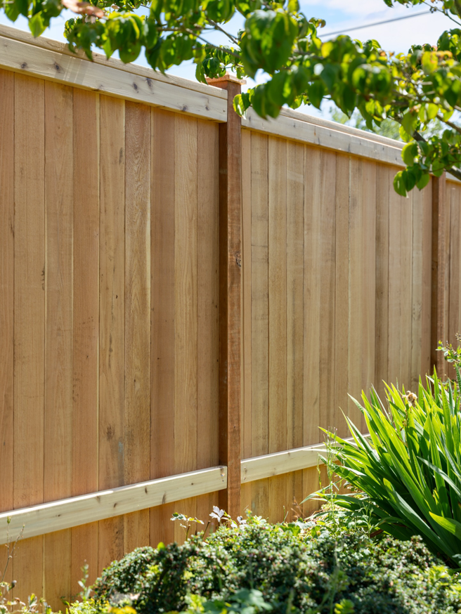 A newly installed wood privacy fence with a top rail, expertly built by Alpine Fencing in Everett, WA.