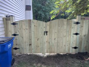 A newly installed wood privacy fence featuring an elegant arched double gate by Superior Fence & Rail Richmond, VA.