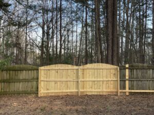 A newly installed wood privacy fence with decorative arched gates by Endurance Fence Solutions, LLC in Holly Springs, NC