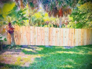 A newly installed wood privacy fence in a residential backyard by Boost My Home in St. Augustine, FL.