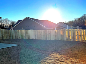 A newly installed wood privacy fence enclosing a backyard by First Class Fence and Landscape LLC in Birmingham, AL.