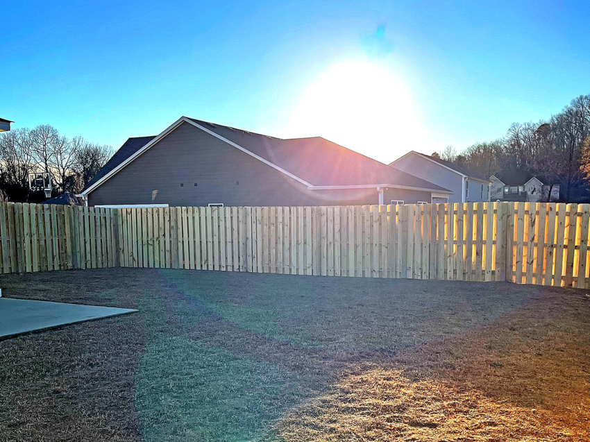 A newly installed wood privacy fence enclosing a backyard by First Class Fence and Landscape LLC in Birmingham, AL.