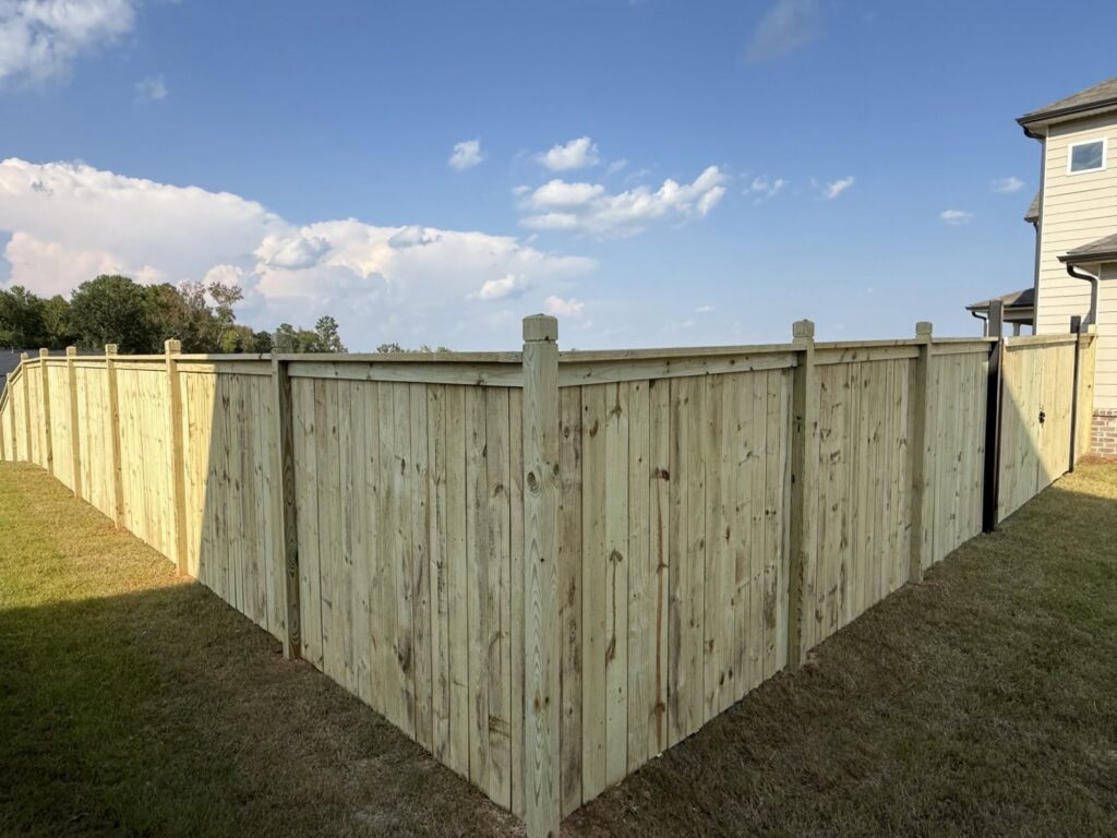 A newly installed wood privacy fence enclosing a backyard by Hawk Fences LLC in Johns Creek, GA.