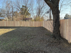 A newly installed wood privacy fence enclosing a backyard by McDaniel Quality Fencing LLC in Muldrow, OK.