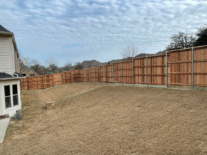 A newly installed wood privacy fence in a residential backyard by Plano Fence and Arbor Pro in Plano, TX.