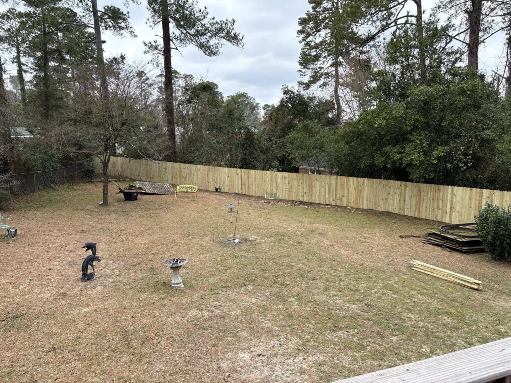 A new wood privacy fence installed in a backyard, replacing an older fence, by CSRA Solutions in Jackson, SC.
