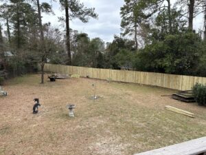 A new wood privacy fence installed in a backyard, replacing an older fence, by CSRA Solutions in Jackson, SC.