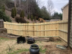 A newly installed wood privacy fence in a residential backyard by Right Now Fencing, LLC in Johns Creek, GA