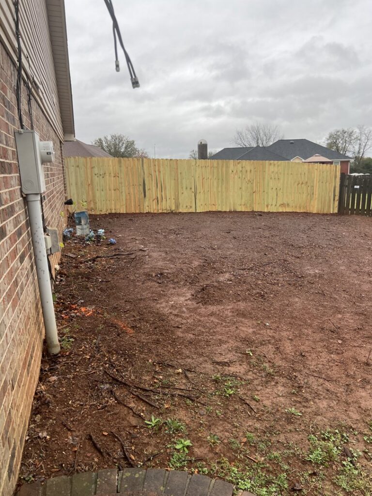 A newly installed wood privacy fence in a residential backyard, completed by RUCO Fence in Huntsville, AL.