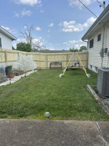 A new wood privacy fence enclosing a backyard with a swing set by Sexton Property Services STL in High Ridge, MO.