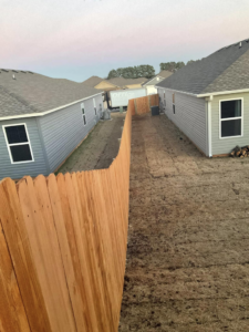 A newly installed wood privacy fence separating two residential properties by Best Fences LLC in Springdale, AR.