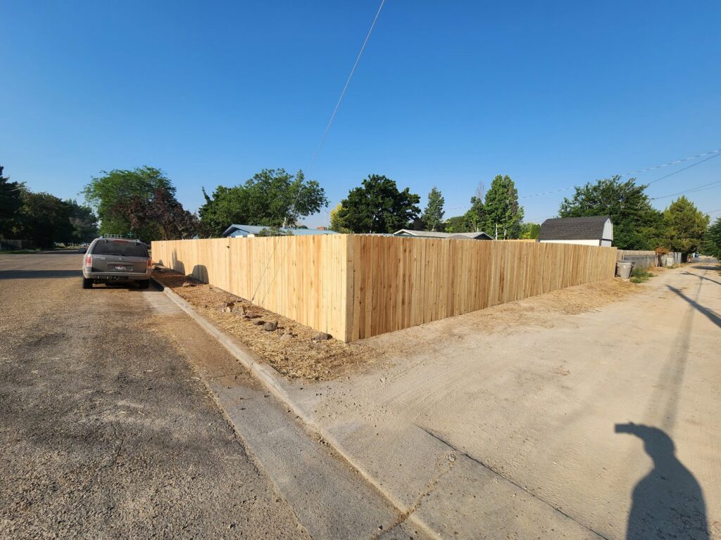A newly installed wooden privacy fence on a corner residential lot by Josey's Fencing LLC in Caldwell, ID.