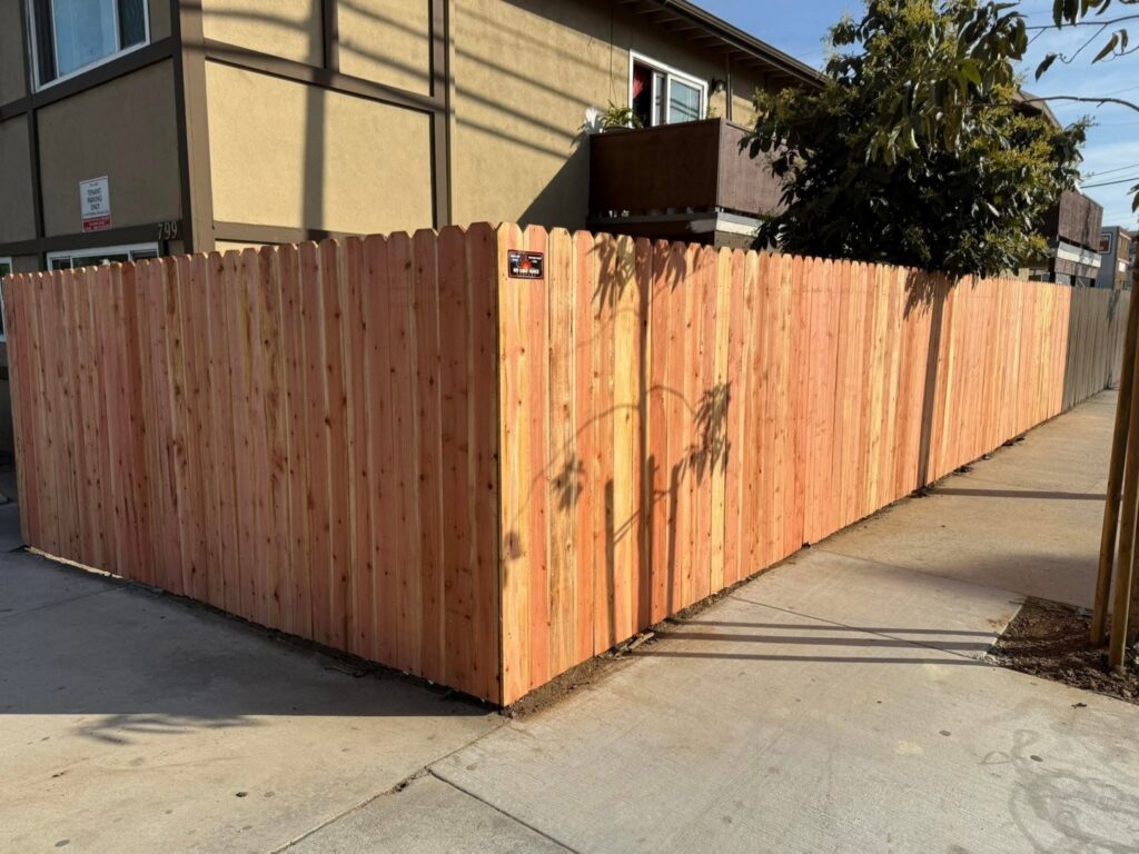 A newly installed wood privacy fence with dog-ear pickets by No Limit Fence Company in Huntington Beach, CA.