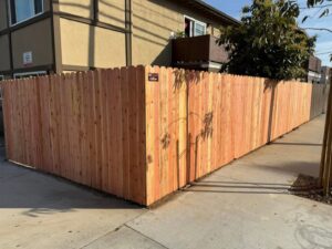 A newly installed wood privacy fence with dog-ear pickets by No Limit Fence Company in Huntington Beach, CA.