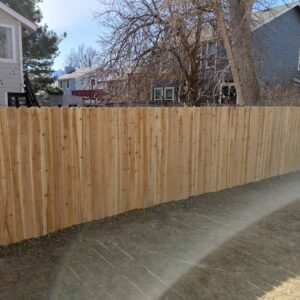 A newly installed wood privacy fence with dog-eared pickets in a residential backyard by Done Wright Fencing and Welding in Denver, CO.