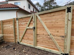 A newly installed wood privacy fence with a double gate for a residential property by National Fence Services, LLC in Macon, GA.