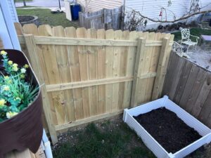 A newly installed wood privacy fence section next to a raised garden bed by Central Ohio Fence in Newark, OH.
