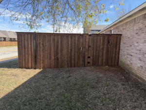 A newly installed wood privacy fence with a gate by Backyard Builders in Rockford, MI.