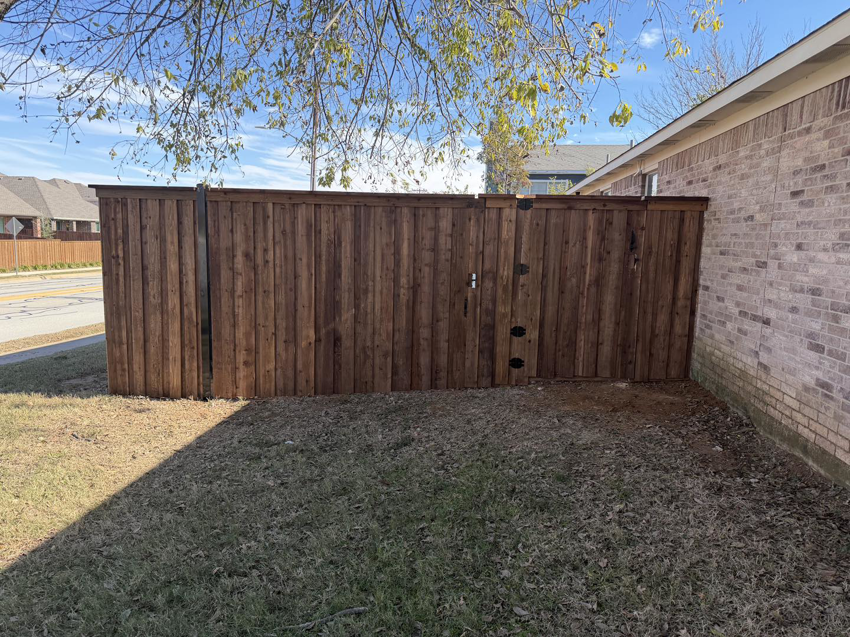 A newly installed wood privacy fence with a gate by Backyard Builders in Rockford, MI.