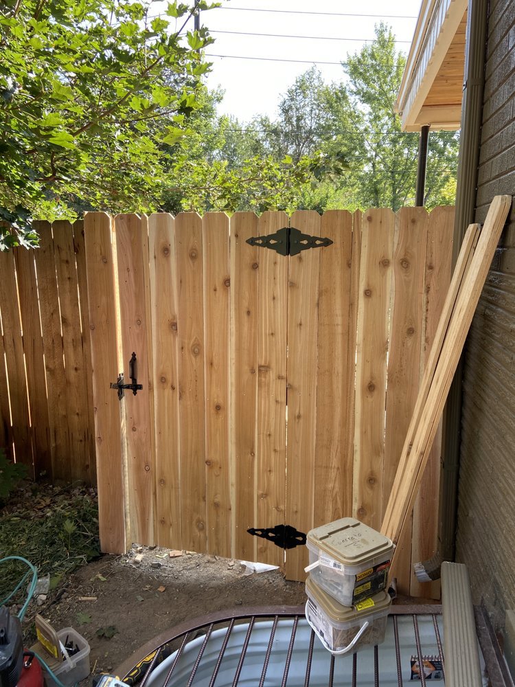 A newly installed wooden privacy fence gate with decorative black hardware by R&S Fencing & Design LLC in Denver, CO.