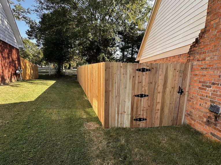 A newly installed wood privacy fence with a gate by Holland Fences and Decks in Bartlett, TN.
