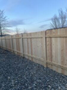 A newly installed wooden privacy fence with a gate next to a residential house by Mule Fence Inc. in Sparks, NV.