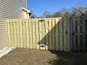 A newly installed wood privacy fence with two gates by Montiel Fence Works in Wilmington, NC.
