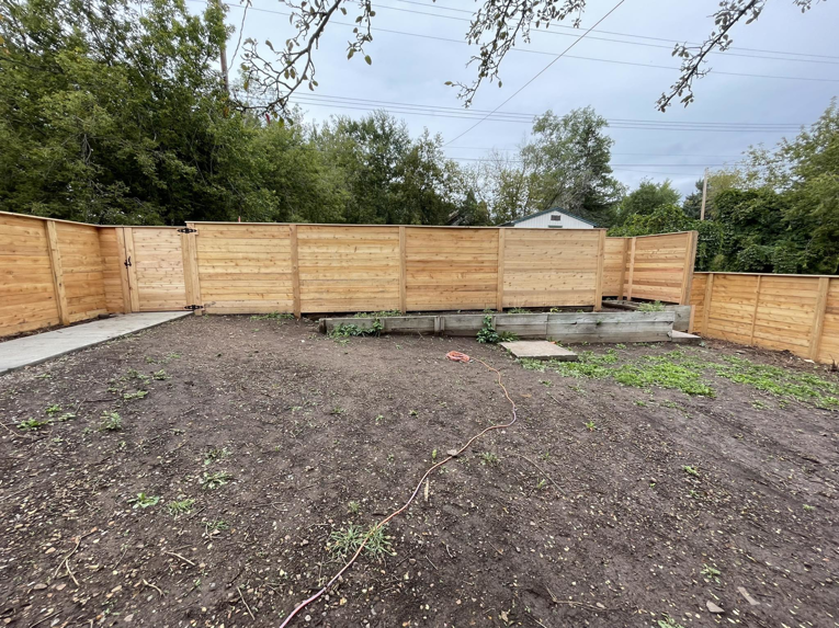 A newly installed wood privacy fence with a gate in a backyard by 218 Fencing in Duluth, MN.