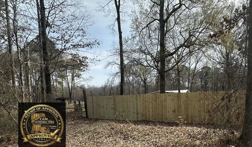 A newly installed wood privacy fence in a natural setting by C & M Affordable Fence, LLC in Haughton, LA