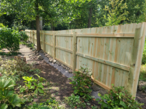 A newly installed wood privacy fence in a residential backyard by Camp Carlson Fencing in Rochester, NY.
