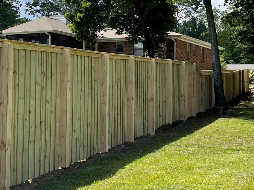 A newly installed wood privacy fence in a residential backyard by First Class Fence and Landscape LLC in Birmingham, AL.