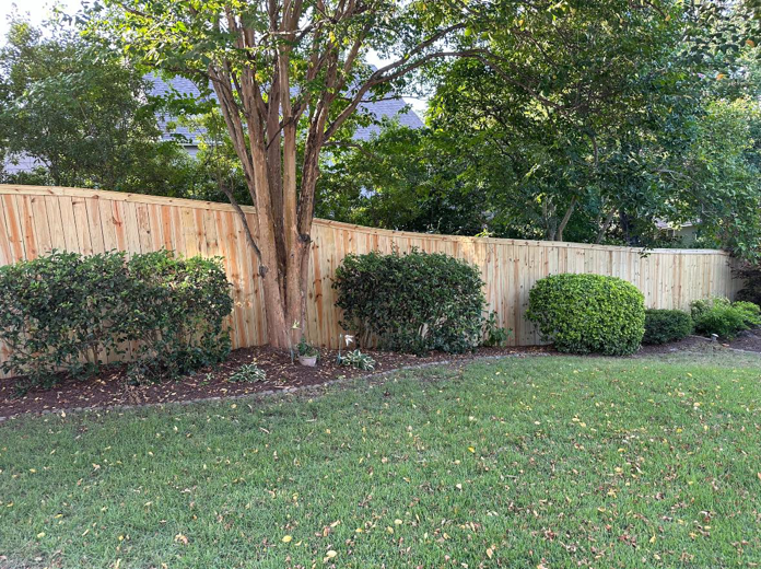 A newly installed wood privacy fence in a backyard by First in Fencing and Remodeling in Fayetteville, NC.