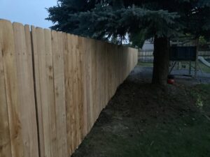A newly installed wooden privacy fence in a residential backyard by Idaho Falls Fencing in Idaho Falls, ID.