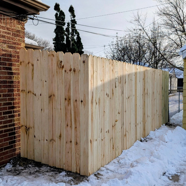 A newly installed wood privacy fence in a residential backyard by Mjölnir Design in Milwaukee, WI.