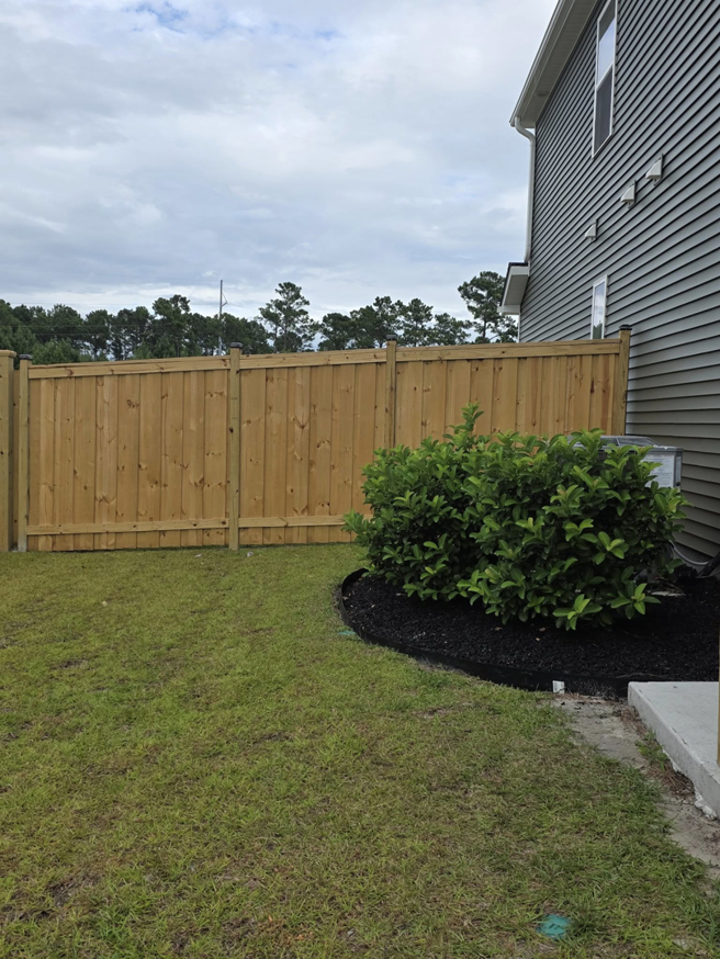 A newly installed wooden privacy fence in a backyard by Montiel Fence Works in Wilmington, NC.