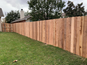 A newly installed wood privacy fence in a residential backyard by Pick-It Fences LLC in Pflugerville, TX.