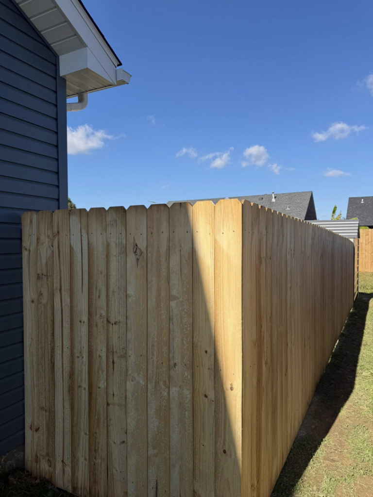 A newly installed wood privacy fence next to a residential home by Quality Deck & Fence LLC in Owensboro, KY