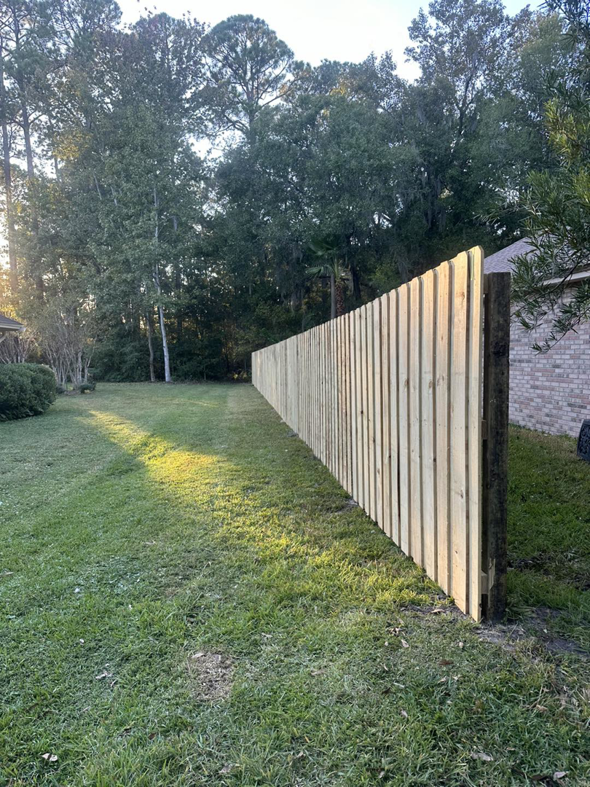 A newly installed wood privacy fence in a residential backyard by R&R Fence Services in Jacksonville, FL.