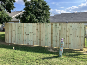 A newly installed wood privacy fence in a residential backyard by Rice&Family Fencing LLC in Greenfield, TN.